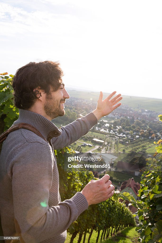 Germany, Bavaria, Volkach, winegrower in vineyard enjoying view