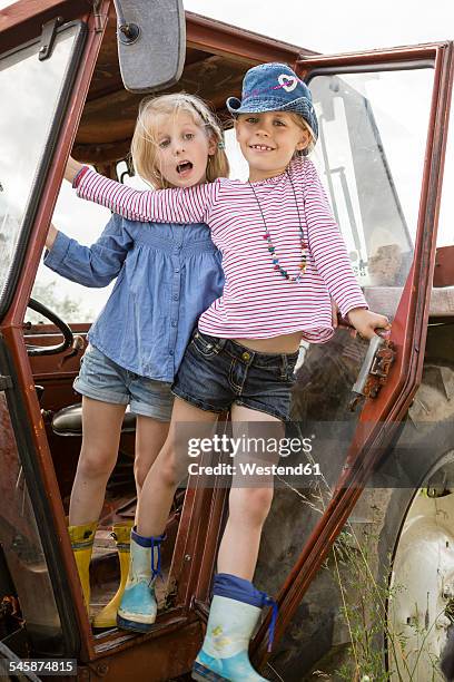 portrait of two smiling little girls standing on a tractor - brandemburgo - fotografias e filmes do acervo