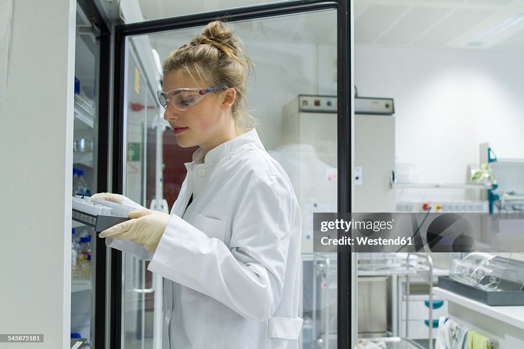 Biologist in laboratory holding rack