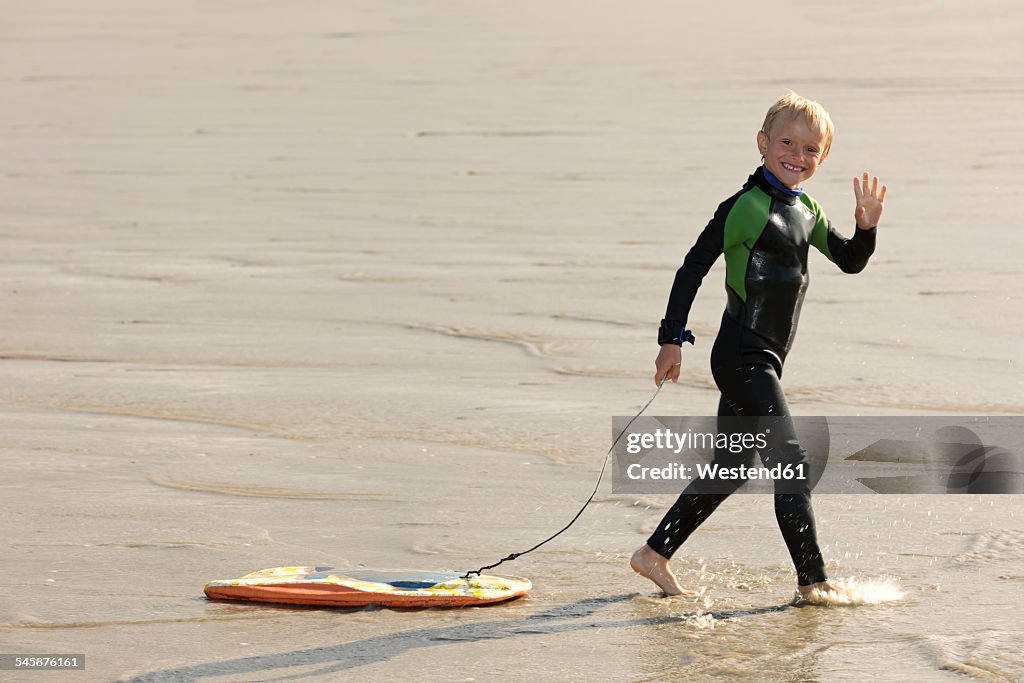 France, Brittany, Finistere, Plage de Treguer, boy with bodyboard