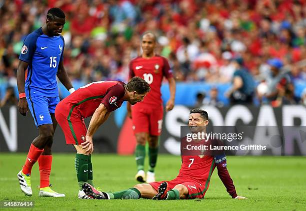 Cristiano Ronaldo of Portugal lies injured as teammate Adrien Silva of Portugal checks on him during the UEFA EURO 2016 Final match between Portugal...