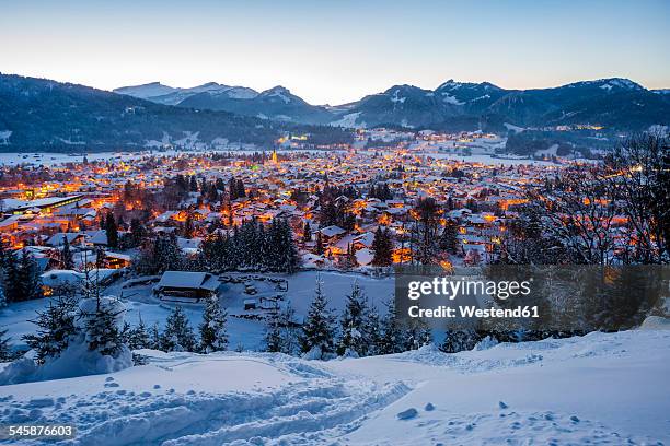 germany, bavaria, view to snow-covered lighted oberstdorf in front of the allgaeu alps - germany snow stock pictures, royalty-free photos & images