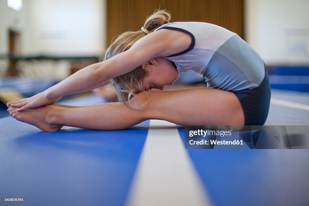 Girl doing gymnastics exercise on floor