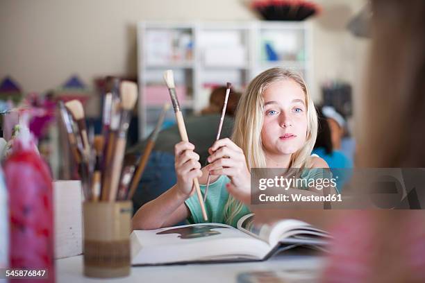 girl in arts class holding brushes - art class stock pictures, royalty-free photos & images