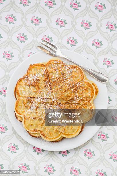 dish of waffles sprinkled with icing sugar on patterned cloth - making waffles stock pictures, royalty-free photos & images