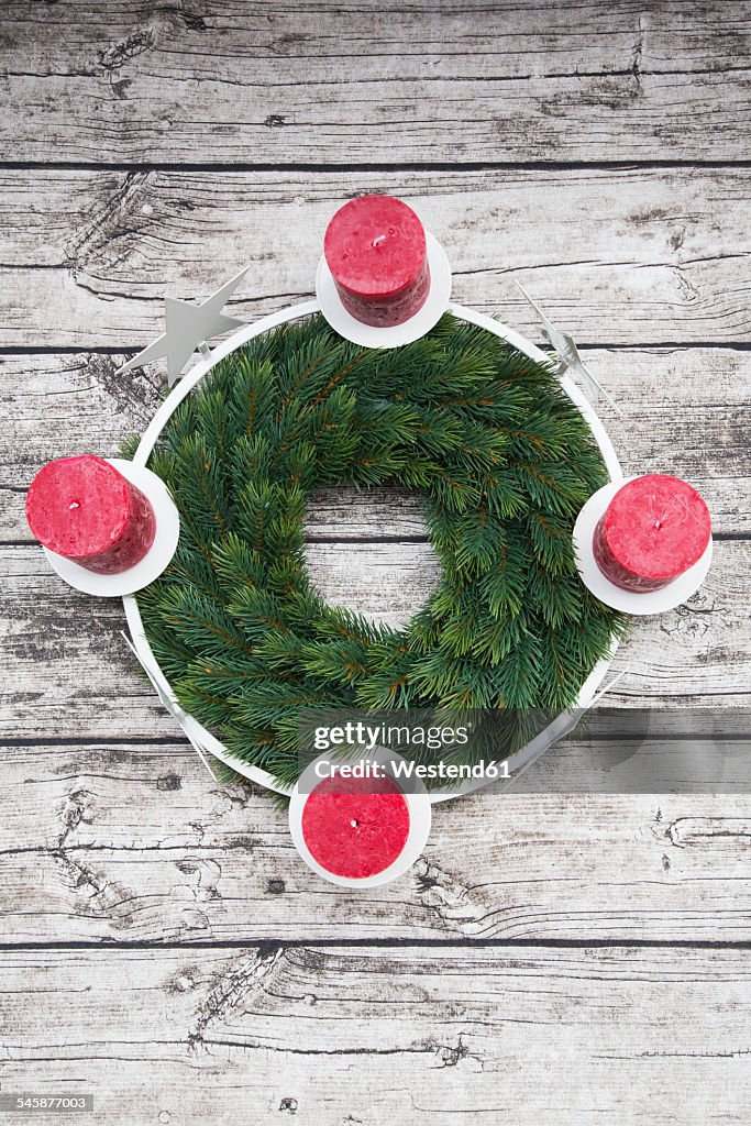 Advent wreath and four candles on wood