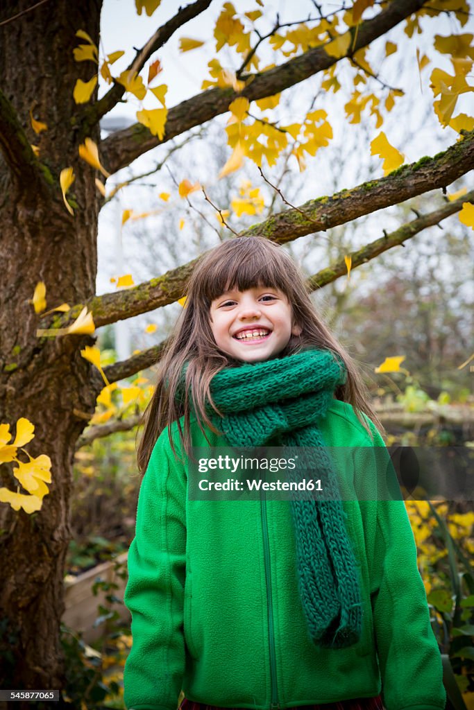 Portrait of grinning girl wearing green scarf and green jacket