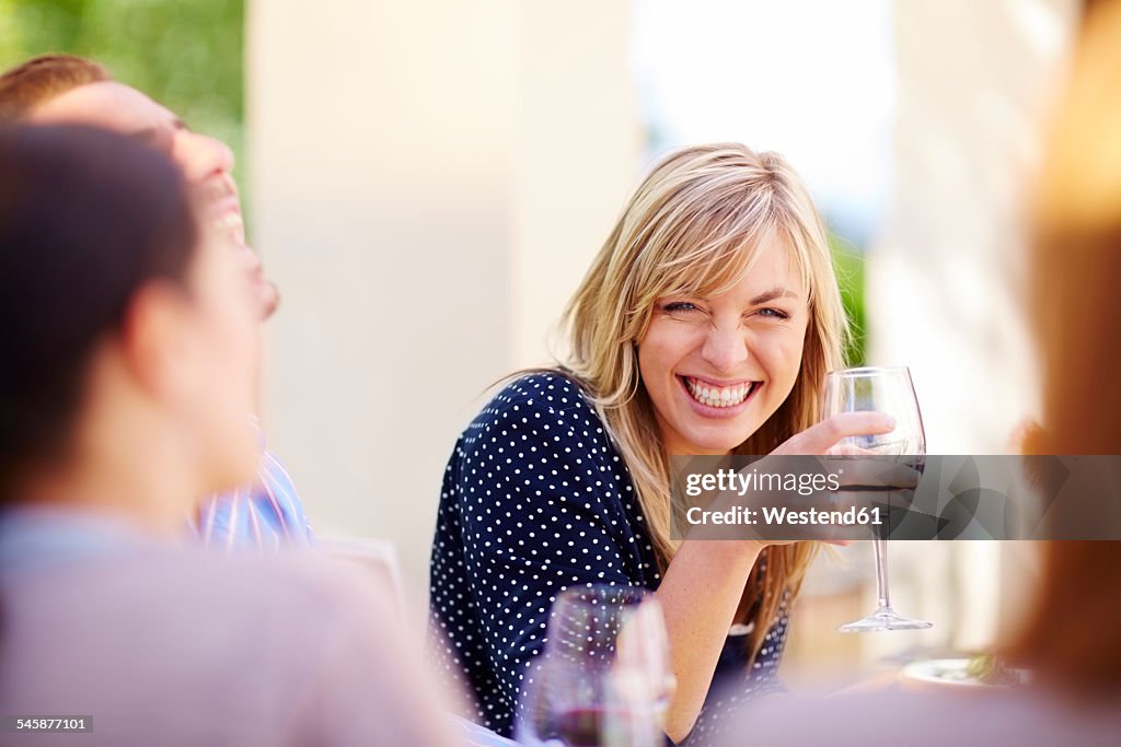 Happy friends with red wine glasses outdoors