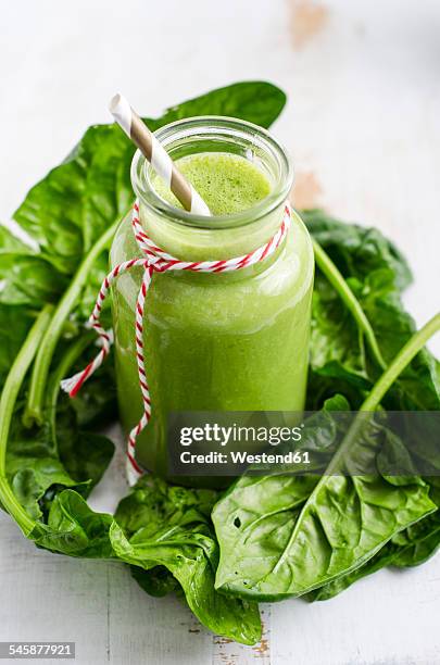 glass of spinach smoothie and spinach leaves on white wood - spinach stock pictures, royalty-free photos & images