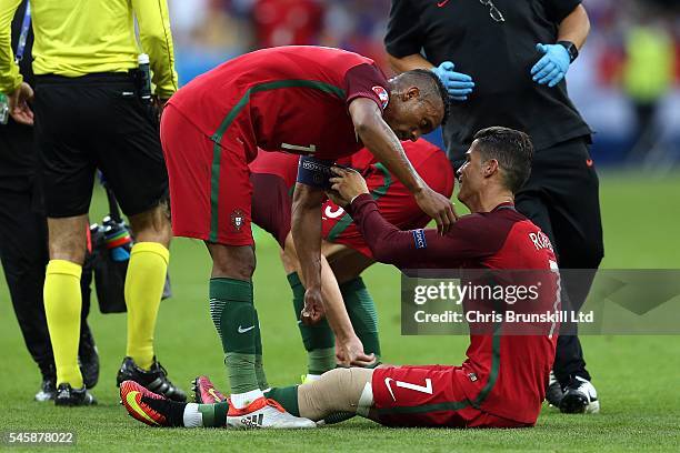 Cristiano Ronaldo of Portugal gives the captain's armband to team-mate Nani before being carried off during the UEFA Euro 2016 Final match between...