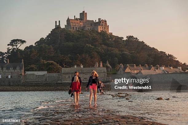 uk, england, cornwall, family on causeway at tidal island st michael's mount - islas de gran bretaña fotografías e imágenes de stock