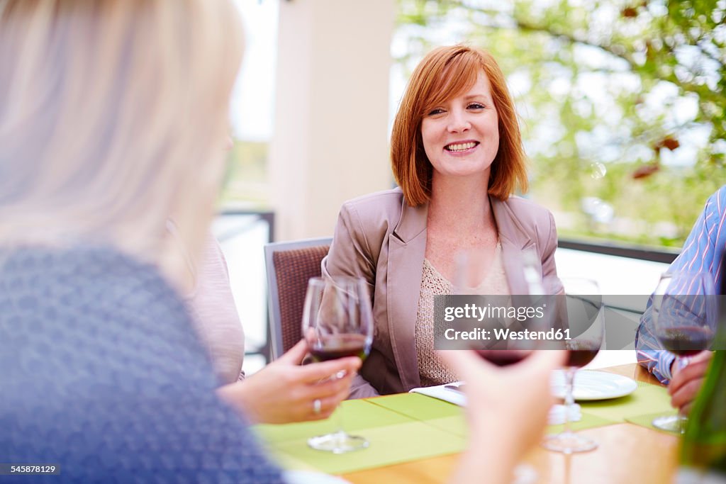 Friends drinking red wine on loggia