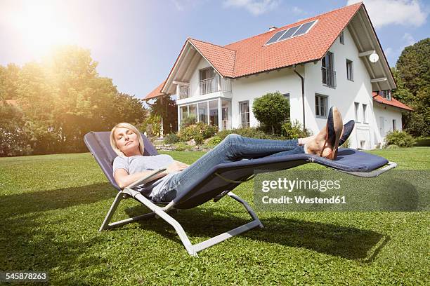 relaxed woman in deck chair in garden - garden in the cloud stock pictures, royalty-free photos & images