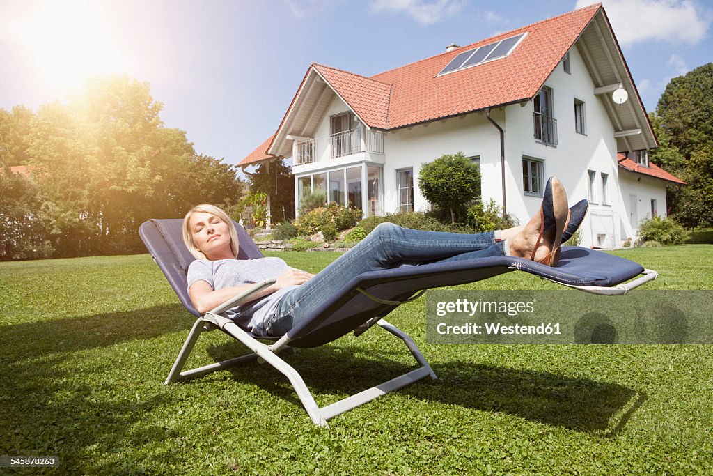 Relaxed woman in deck chair in garden