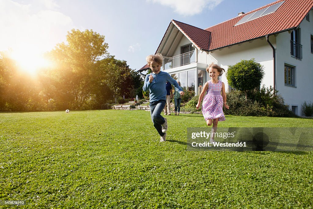 Brother and sister running in garden