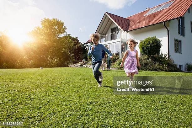 brother and sister running in garden - grounds imagens e fotografias de stock