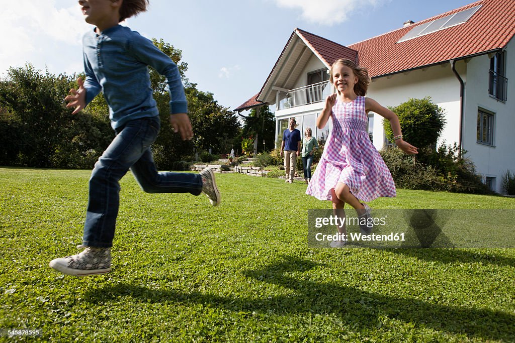Brother and sister running in garden