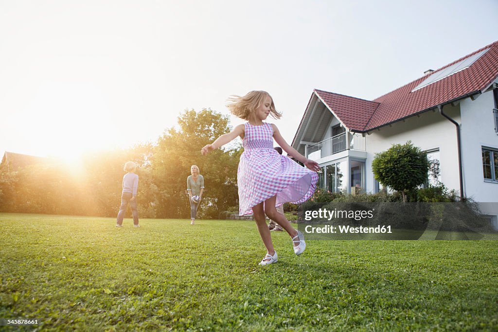 Girl in motion with family in garden