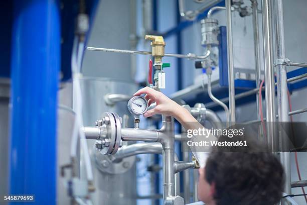 woman with lab coat in technical room with a fermenter - druckmesser stock-fotos und bilder
