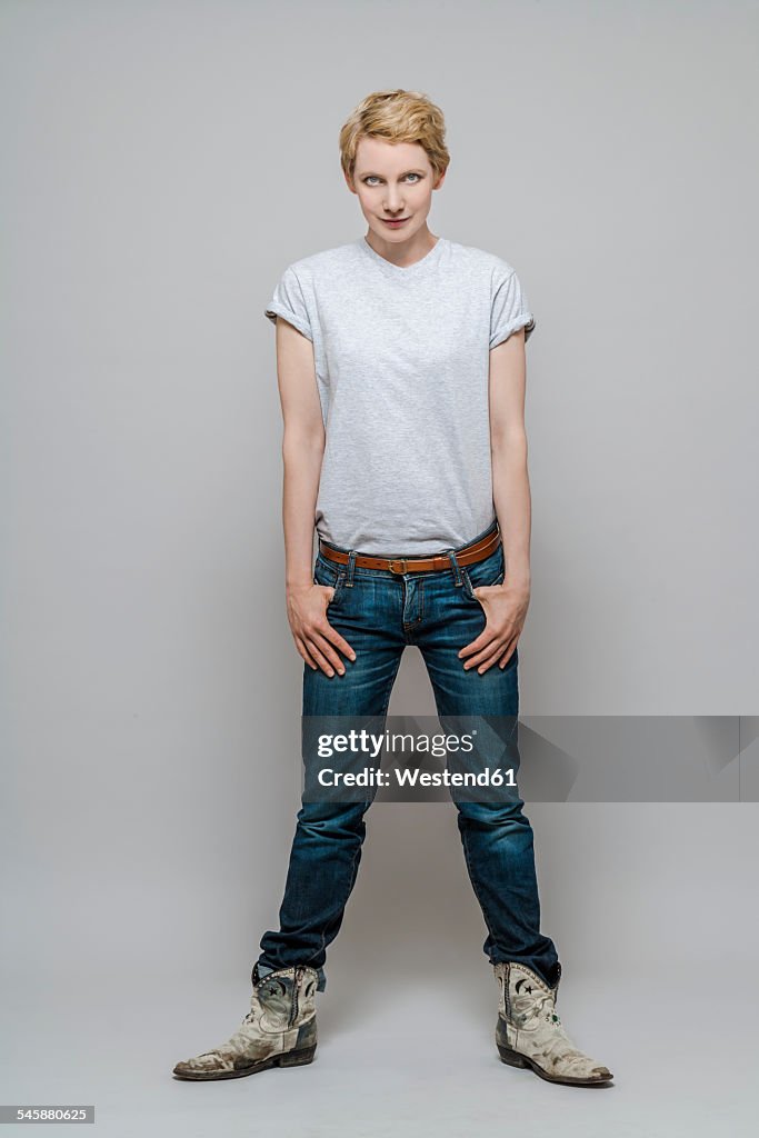 Aggressive woman standing in front of grey background