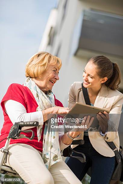 granddaughter and her grandmother with digital tablet - oma rollator stockfoto's en -beelden
