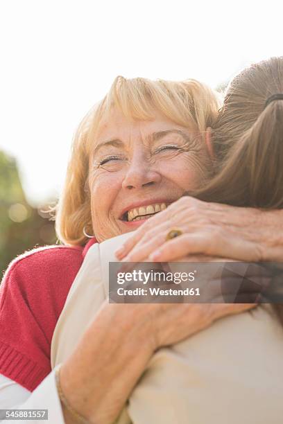 portrait of happy senior woman hugging ger granddaughter - thank you smile stock pictures, royalty-free photos & images