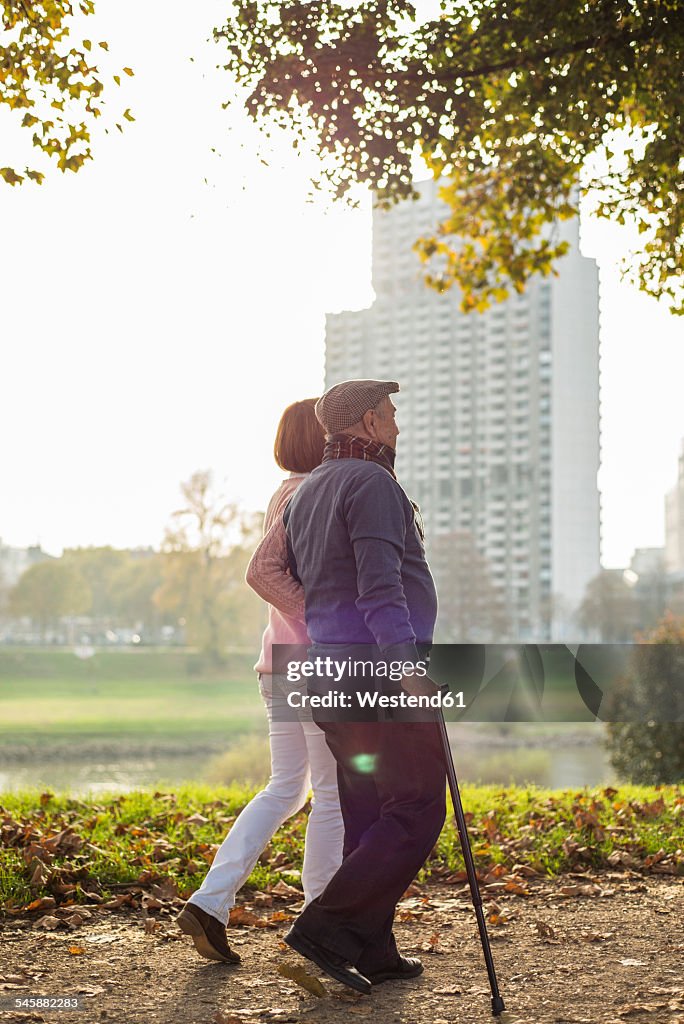 Daughter and senior man walking by the riverside