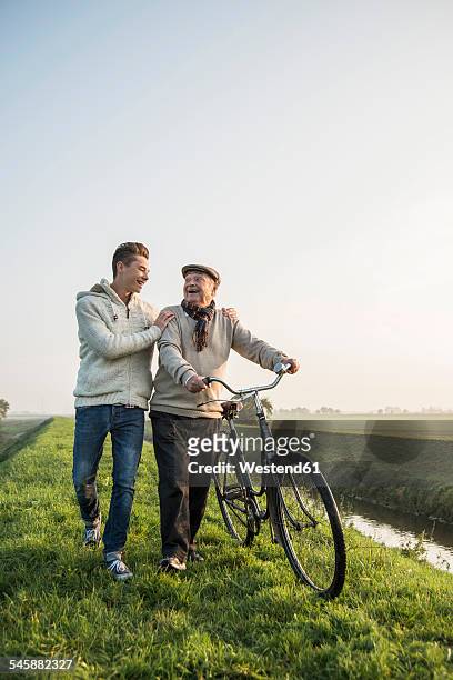 senior man and grandson in rural landscape with bicycle - levee - fotografias e filmes do acervo