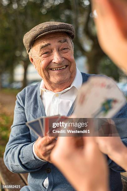 senior man and grandson playing cards - senior men playing cards stock pictures, royalty-free photos & images