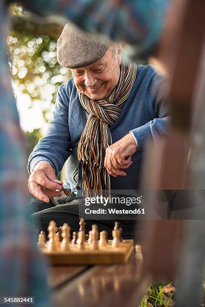 senior man and grandson playing chess - senior playing chess stock pictures, royalty-free photos & images