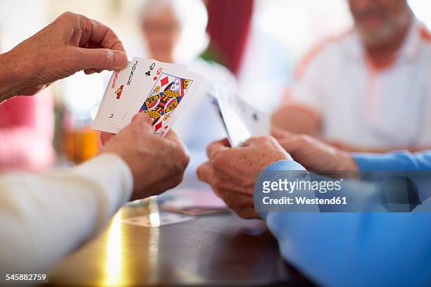 senior friends playing cards - kaartspel stockfoto's en -beelden