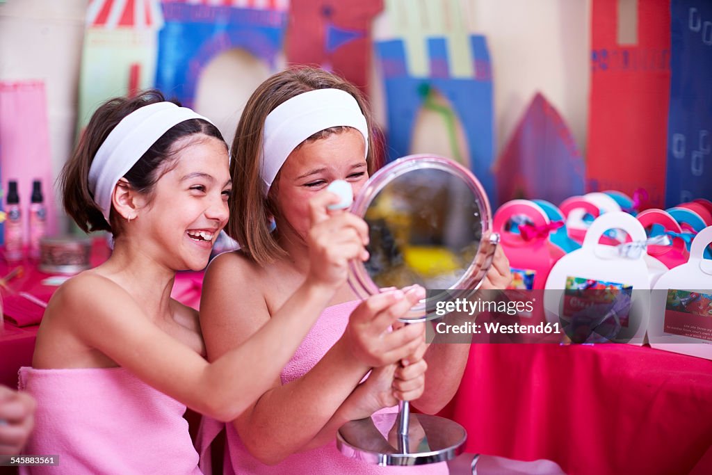 Two girls on a beauty farm looking in mirror