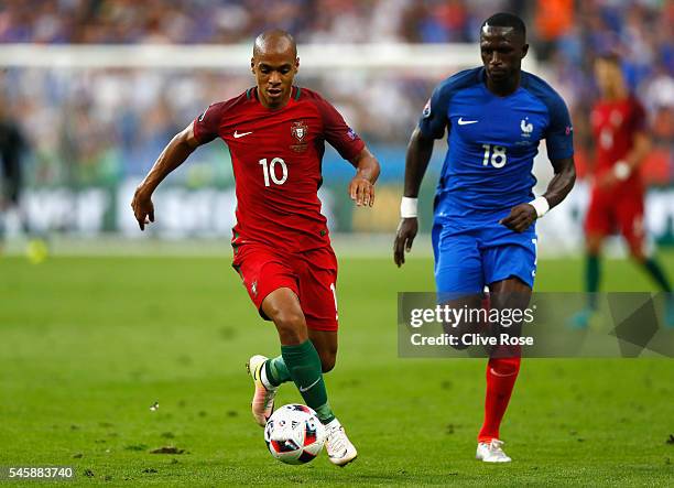 Joao Mario of Portugal in action with Moussa Sissoko of France during the UEFA EURO 2016 Final match between Portugal and France at Stade de France...