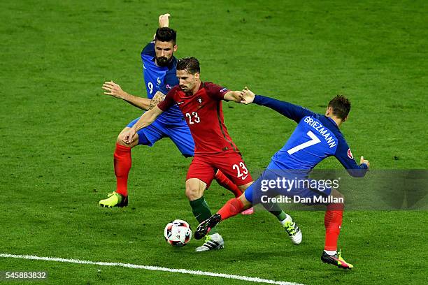 Adrien Silva of Portugal takes on Olivier Giroud and Antoine Griezmann of France during the UEFA EURO 2016 Final match between Portugal and France at...