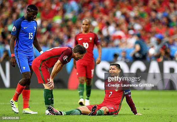 Cristiano Ronaldo of Portugal lies injured as teammate Adrien Silva of Portugal checks on him during the UEFA EURO 2016 Final match between Portugal...