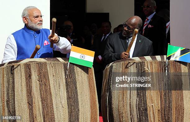 India's Prime Minister Narendra Modi and Tanzania's President John Magufuli play drums at State House in Dar es Salaam on July 10, 2016. Modi is on...