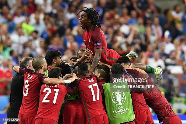 Portugal's midfielder Renato Sanches jumps on teammates after Portugal's forward Eder scored the first goal of the match during the Euro 2016 final...