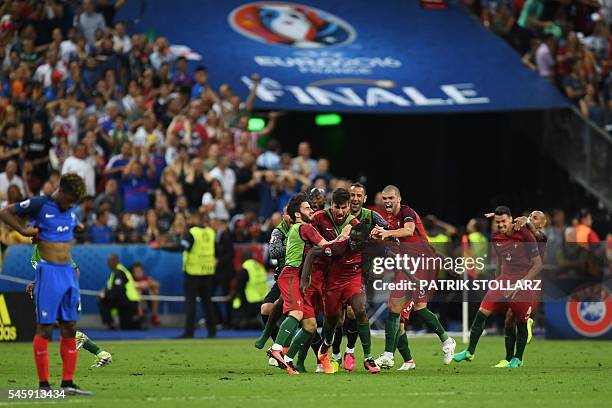 Portugal's forward Eder celebrates with teammates after he scored during the Euro 2016 final football match between Portugal and France at the Stade...