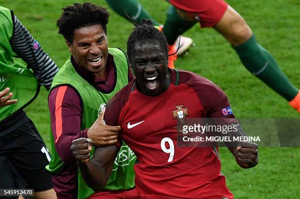 Portugal's forward Eder celebrates with Portugal's defender Eliseu after scoring a goal during the Euro 2016 final football match between Portugal...