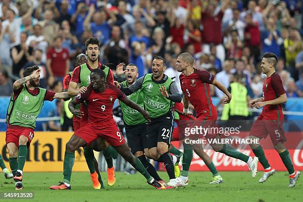 Portugal's forward Eder celebrates with teammates after scoring a goal during the Euro 2016 final football match between Portugal and France at the...