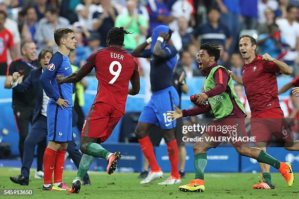 France's forward Antoine Griezmann looks on as Portugal's forward Eder celebrates after scoring a goal during the Euro 2016 final football match...