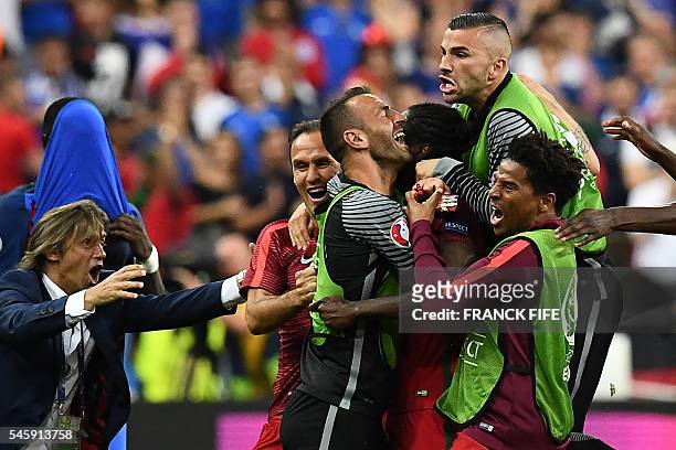 Portugal's forward Eder celebrates with teammates their first goal during the Euro 2016 final football match between France and Portugal at the Stade...