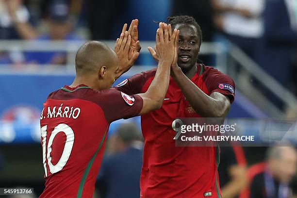 Portugal's forward Eder celebrates with Portugal's midfielder Joao Mario after scoring a goal during the Euro 2016 final football match between...