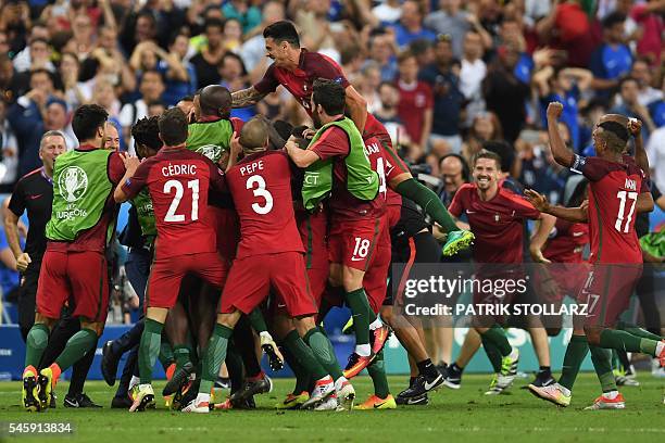 Portugal's forward Eder celebrates with teammates after he scored during the Euro 2016 final football match between Portugal and France at the Stade...