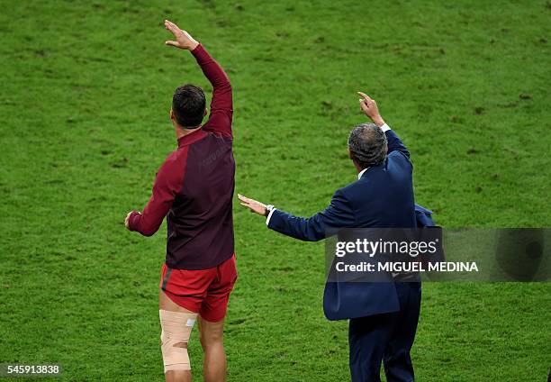 Portugal's forward Cristiano Ronaldo and Portugal's coach Fernando Santos celebrate their team's win in the Euro 2016 final football match between...