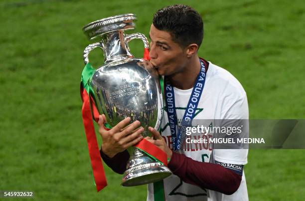 Portugal's forward Cristiano Ronaldo kisses the trophy after the team's 1-0 win in the Euro 2016 final football match between Portugal and France at...