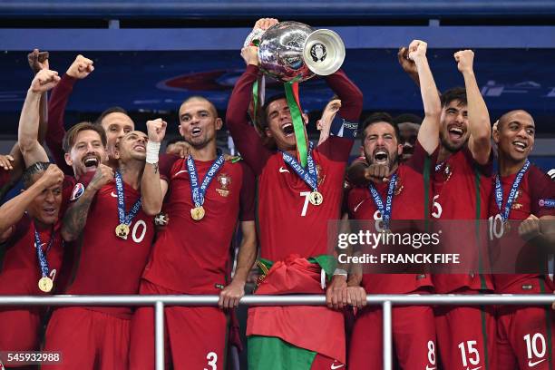 Portugal's captain and forward Cristiano Ronaldo hold up the winners' trophy in the Euro 2016 final football match between France and Portugal at the...