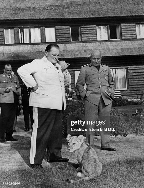 Im Garten von Carinhall in der Schorfheidebei Berlin: Hermann Göring und BenitoMussolini mit einem jungen Löwen; links:Reichsminister Hans Frank