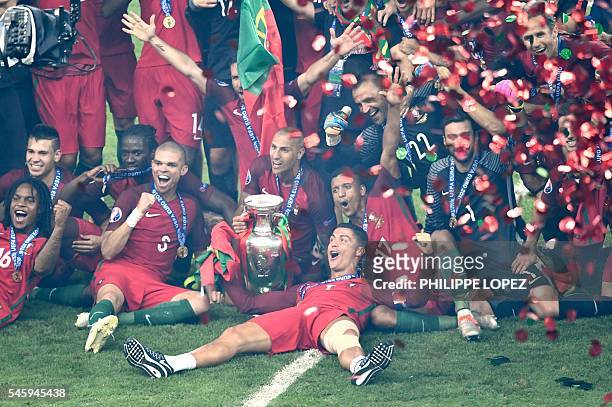 Portugal's forward Cristiano Ronaldo poses with team mates and the trophy for a photo after their team's 1-0 win in the Euro 2016 final football...