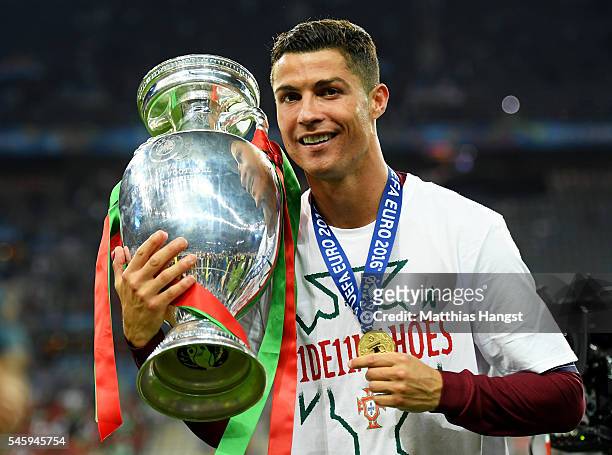 Cristiano Ronaldo of Portugal poses for photographs with the Henri Delaunay trophy to celebrate after his team's 1-0 win against France in the UEFA...